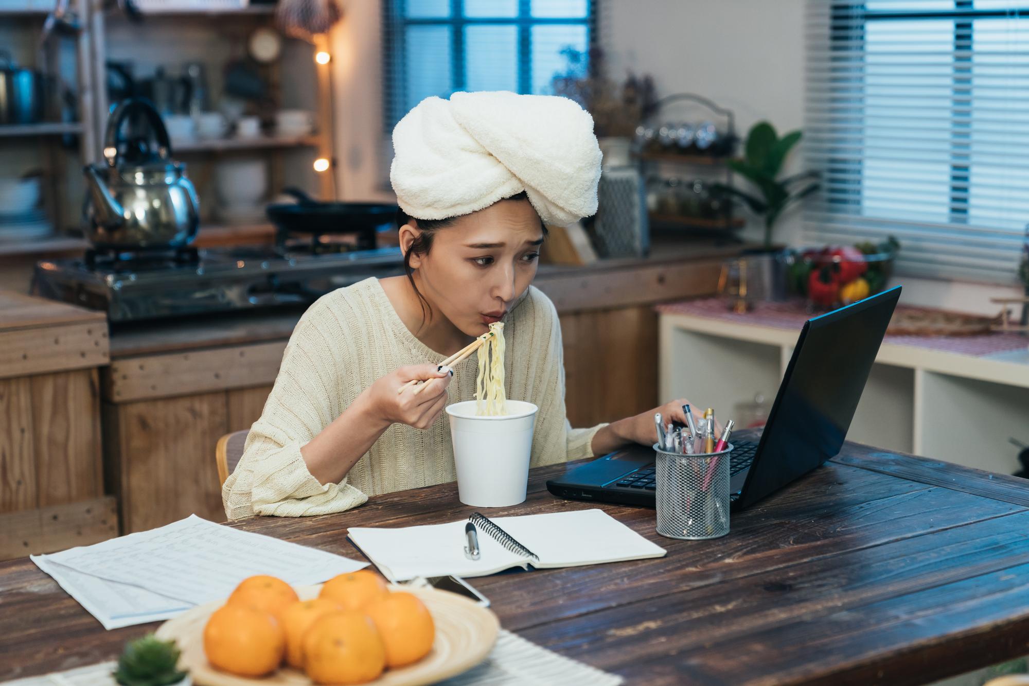 Student following recipe on laptop in kitchen